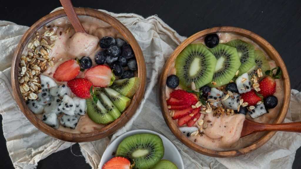 kiwi kuttet i biter og blåbær i en trebolle
